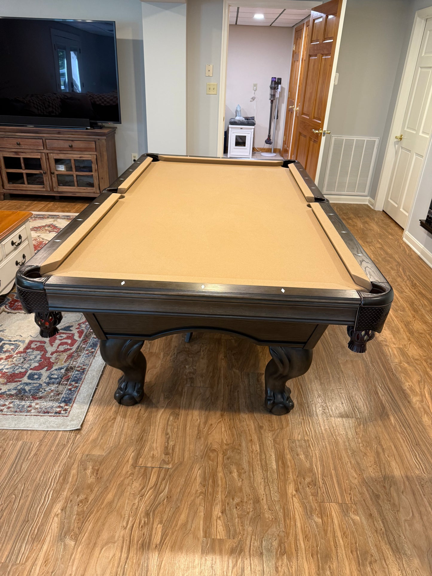 Pool table in a room with wooden flooring