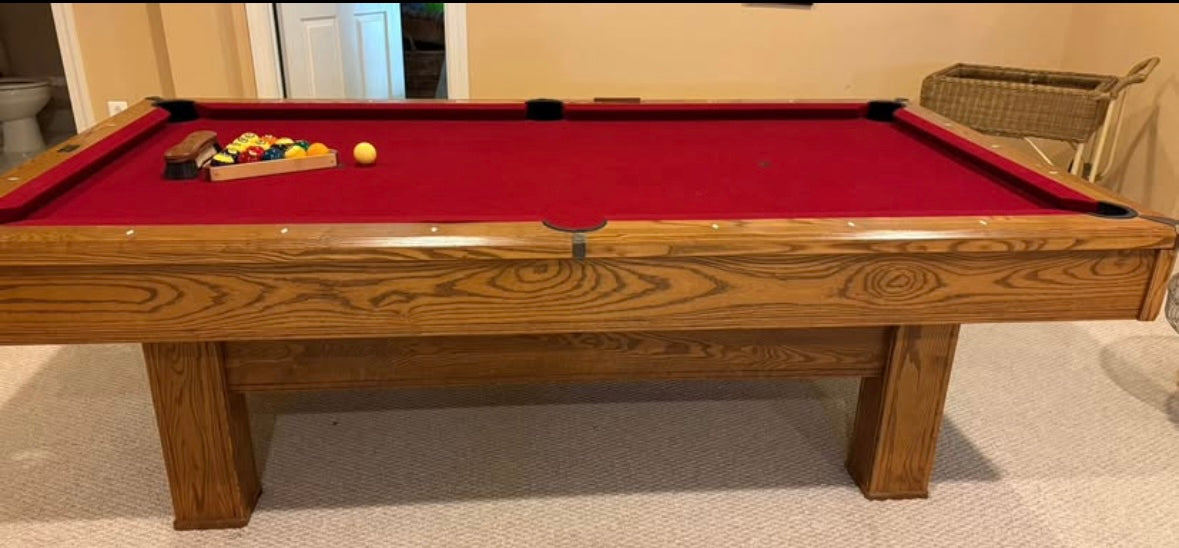 Wooden pool table with red felt