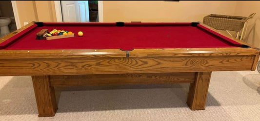 Wooden pool table with red felt