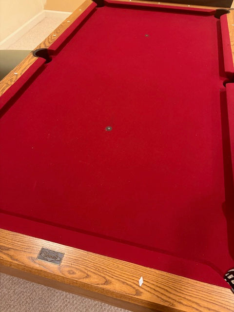 Red pool table with wooden frame and red felt