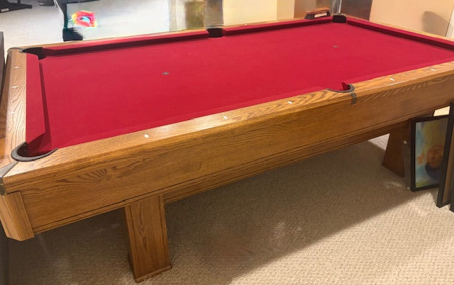 Wooden pool table with red felt