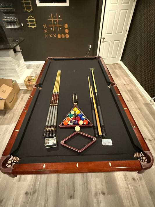 Overhead view of pool table with cues 
