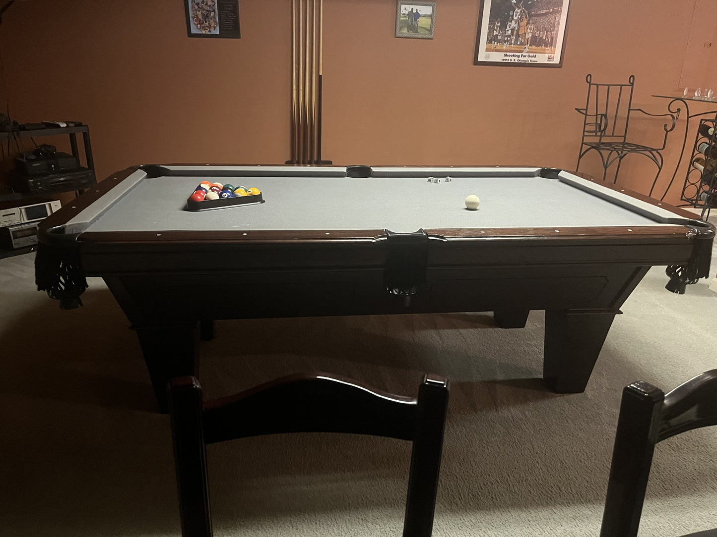 Pool table with balls in a room with chairs