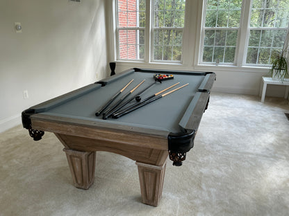 Pool table with grey felt with cues and balls
