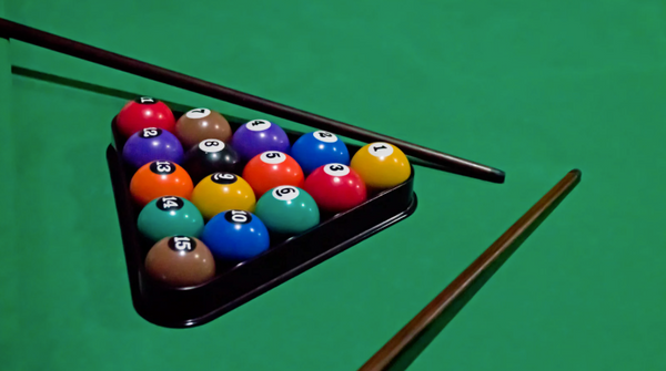 Pool balls and cues on a green felt table