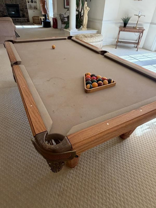 Pool table with balls and a billiard triangle in a living room setting